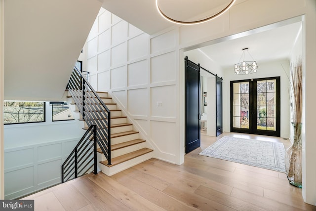 1544 Forest Villa Ln, Mclean, VA 22101 - entryway with a decorative wall, healthy amount of natural light, a barn door, light wood-style flooring, and stairway