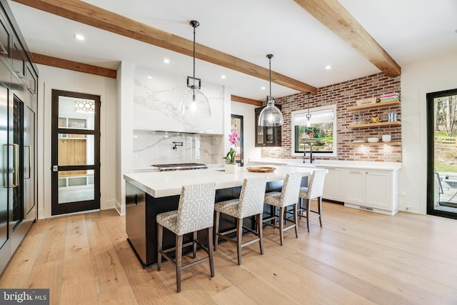 1544 Forest Villa Ln, Mclean, VA 22101 - kitchen with light wood finished floors, beam ceiling, light countertops, white cabinetry, and a kitchen island