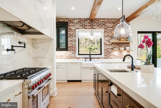 1544 Forest Villa Ln, Mclean, VA 22101 - kitchen featuring range with two ovens, a sink, beamed ceiling, light wood-style flooring, and wall chimney exhaust hood