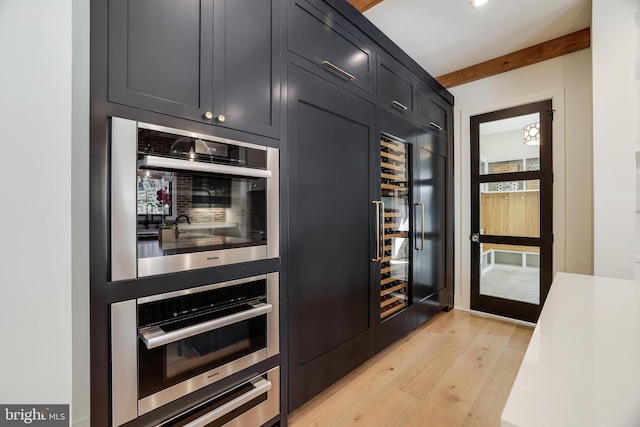 1544 Forest Villa Ln, Mclean, VA 22101 - kitchen featuring light wood-style floors, recessed lighting, stainless steel double oven, dark cabinetry, and light countertops