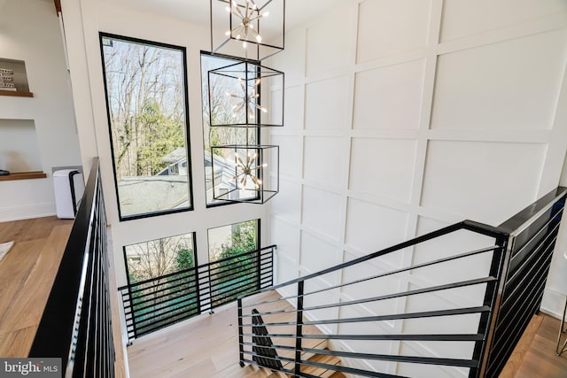 1544 Forest Villa Ln, Mclean, VA 22101 - stairs featuring a chandelier, wood finished floors, a decorative wall, and baseboards