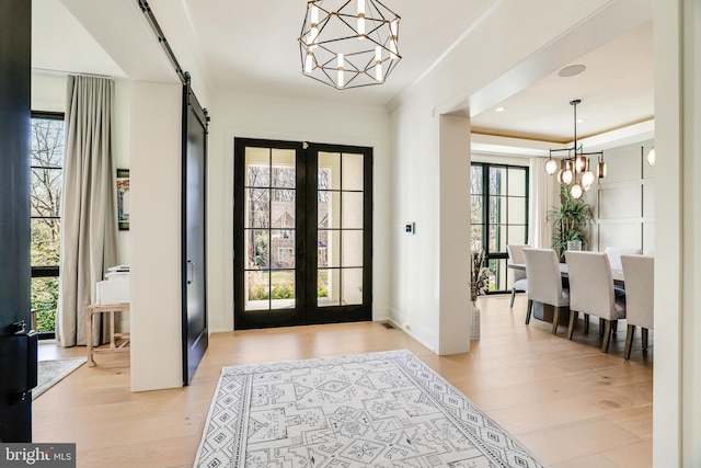 1544 Forest Villa Ln, Mclean, VA 22101 - foyer featuring a chandelier, a barn door, light wood finished floors, and a raised ceiling