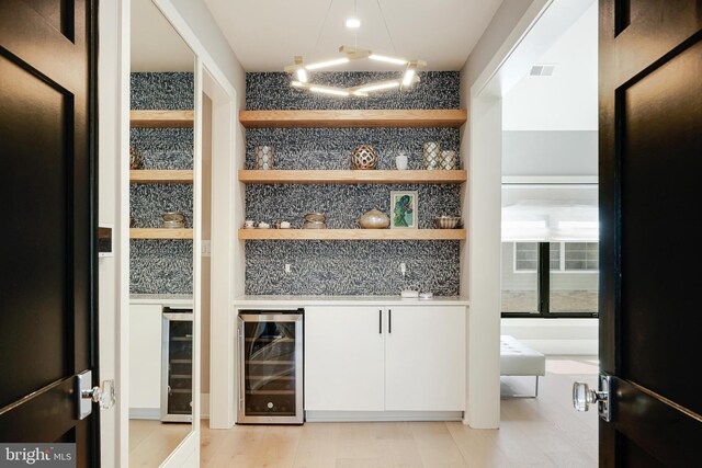 1544 Forest Villa Ln, Mclean, VA 22101 - bar area featuring wine cooler, black fridge, freestanding refrigerator, and light wood-style flooring