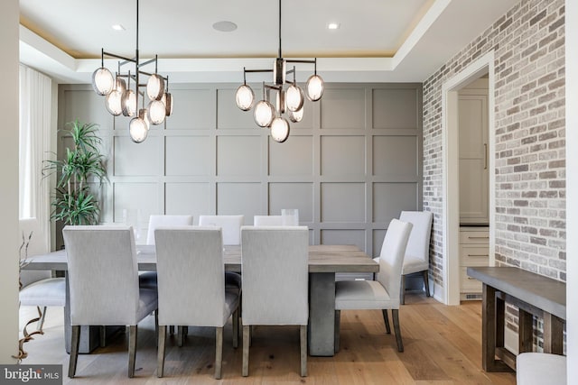 1544 Forest Villa Ln, Mclean, VA 22101 - dining area featuring a decorative wall, a chandelier, light wood-style floors, brick wall, and an accent wall