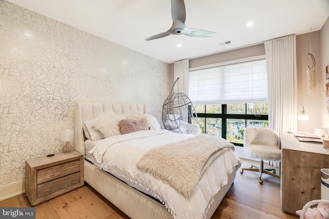1544 Forest Villa Ln, Mclean, VA 22101 - bedroom with wallpapered walls, an accent wall, wood finished floors, recessed lighting, and a ceiling fan
