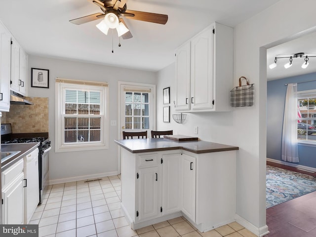 kitchen featuring white cabinets, stainless steel gas range, ceiling fan, dark countertops, and under cabinet range hood