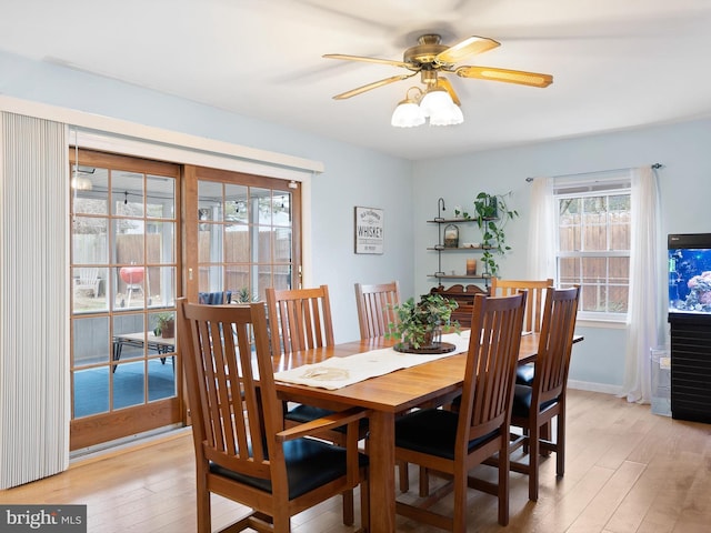 dining space featuring baseboards, light wood-style floors, and ceiling fan