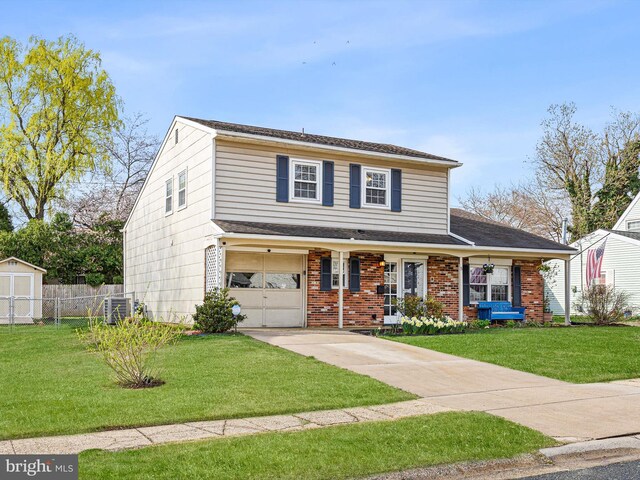 traditional-style house featuring concrete driveway, fence, a front lawn, brick siding, and a garage