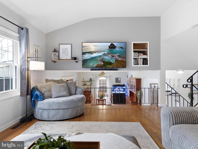 living room featuring a ceiling fan, baseboards, lofted ceiling, and wood finished floors