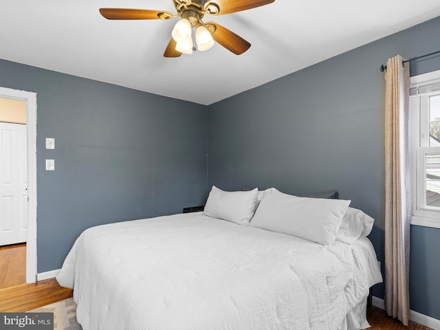 bedroom with baseboards, wood finished floors, and ceiling fan