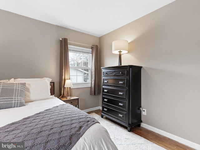 bedroom featuring baseboards and light wood finished floors