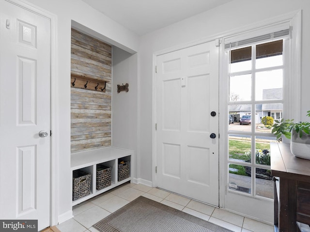 mudroom featuring wood walls, light tile patterned floors, and plenty of natural light