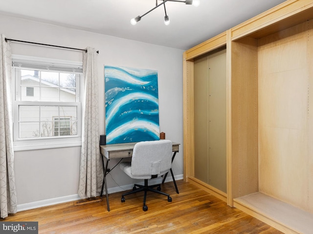 office space featuring visible vents, baseboards, and wood finished floors