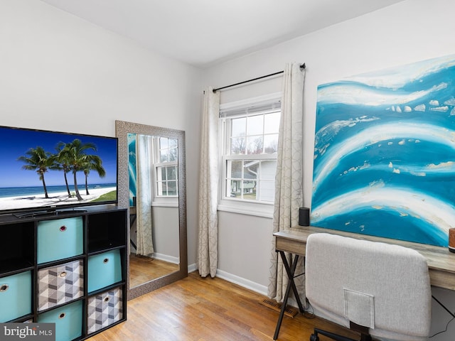 home office with baseboards and wood finished floors