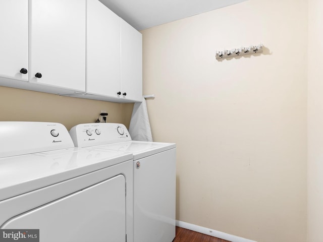 laundry room with baseboards, cabinet space, wood finished floors, and washer and dryer