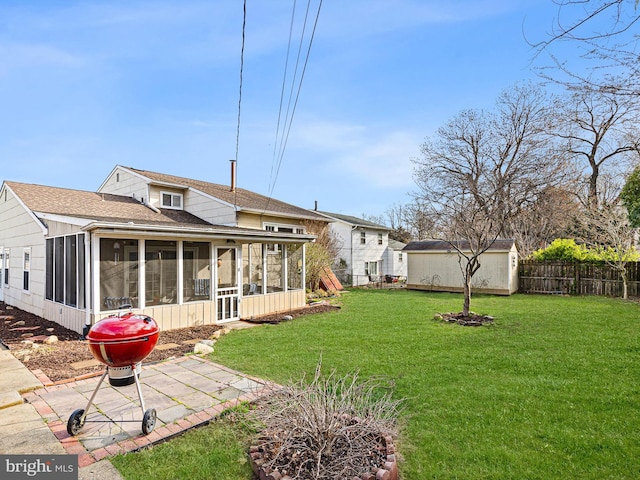 back of house featuring an outbuilding, fence, a shingled roof, a sunroom, and a yard