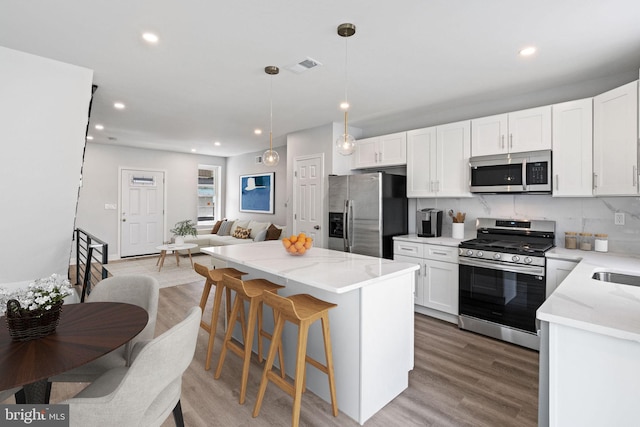 1404 S Patton St, Philadelphia, PA 19146 - kitchen with open floor plan, white cabinets, light wood-type flooring, and appliances with stainless steel finishes