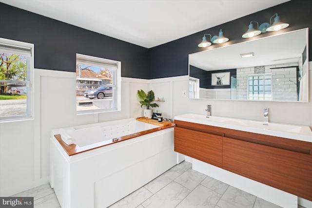 full bathroom with a bath, a healthy amount of sunlight, marble finish floor, and a wainscoted wall