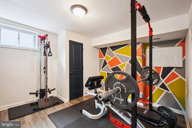 workout area featuring wood finished floors and baseboards