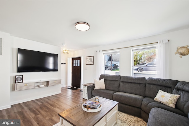living area featuring baseboards and wood finished floors