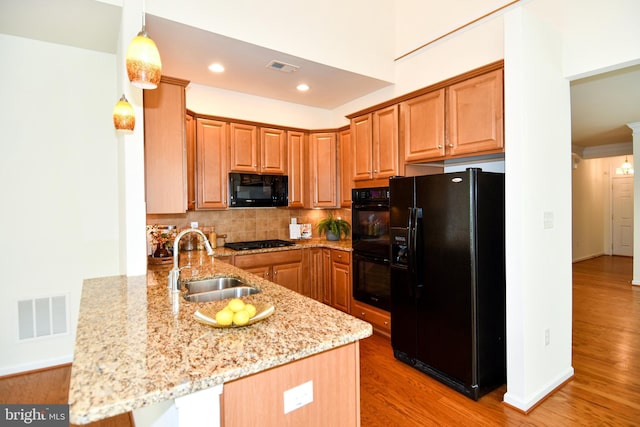 20559 Crescent Pointe Pl, Ashburn, VA 20147 - kitchen featuring black appliances, a sink, a peninsula, light wood finished floors, and backsplash