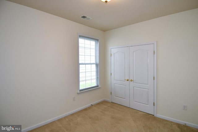 20559 Crescent Pointe Pl, Ashburn, VA 20147 - unfurnished bedroom featuring multiple windows, light carpet, baseboards, and a closet