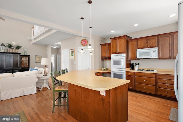 304 S Heron Gull Ct, Ocean City, MD 21842 - kitchen with open floor plan, light countertops, light wood-style floors, and white appliances