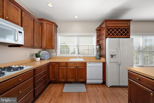 304 S Heron Gull Ct, Ocean City, MD 21842 - kitchen featuring light wood-type flooring, light countertops, a sink, and white appliances