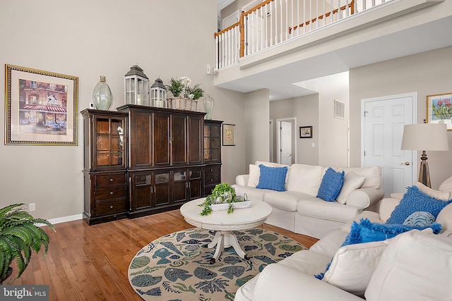 304 S Heron Gull Ct, Ocean City, MD 21842 - living area featuring baseboards, a towering ceiling, visible vents, and light wood finished floors
