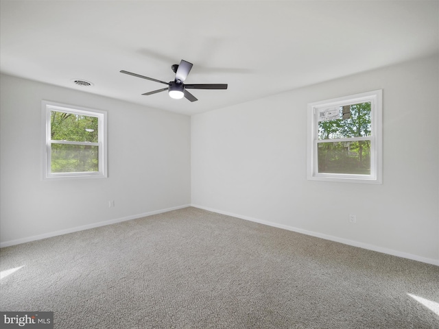 unfurnished room featuring baseboards, a ceiling fan, visible vents, and carpet flooring