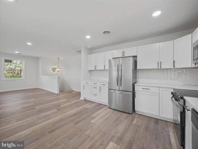 kitchen featuring white cabinets, light wood-style flooring, appliances with stainless steel finishes, and tasteful backsplash