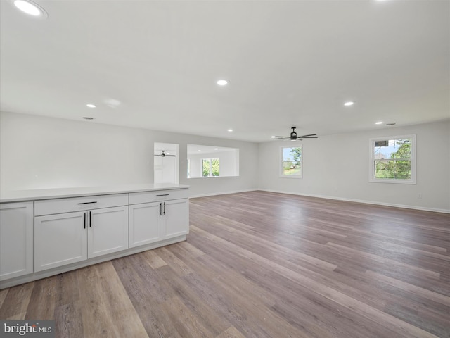 unfurnished living room with recessed lighting, light wood-style flooring, and a healthy amount of sunlight