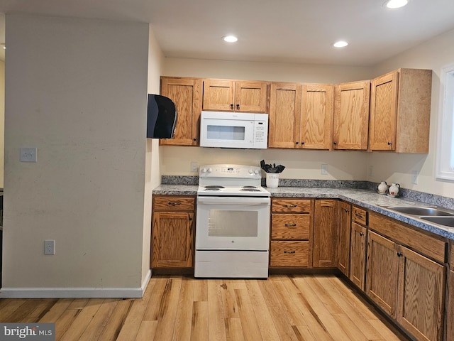 kitchen featuring recessed lighting, a sink, light wood-style floors, and white appliances