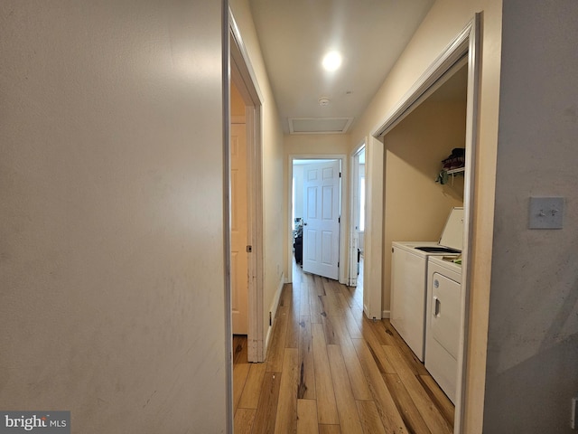 corridor featuring baseboards, washing machine and dryer, and light wood-type flooring