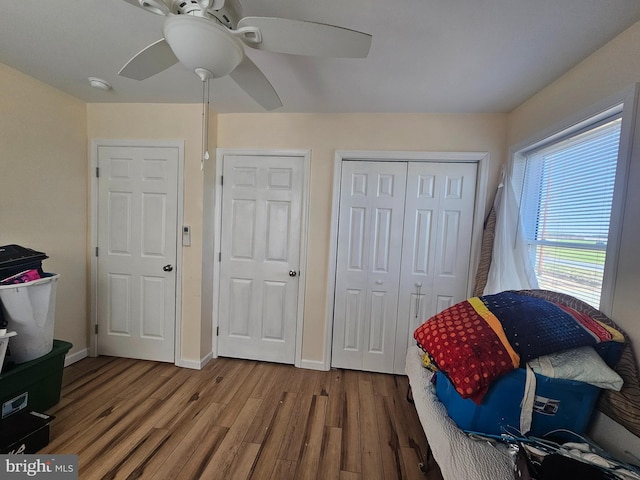 bedroom with baseboards, a closet, wood finished floors, and ceiling fan