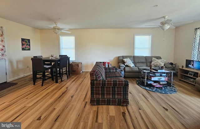 living room with baseboards, wood finished floors, and a ceiling fan