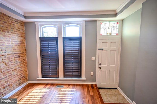 6 N Luzerne Ave, Baltimore, MD 21224 - foyer featuring crown molding, hardwood / wood-style floors, plenty of natural light, baseboards, and brick wall