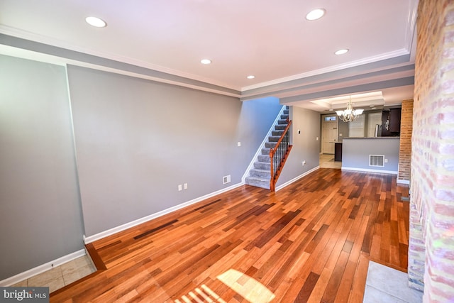 6 N Luzerne Ave, Baltimore, MD 21224 - unfurnished living room with a chandelier, stairway, wood-type flooring, baseboards, and crown molding