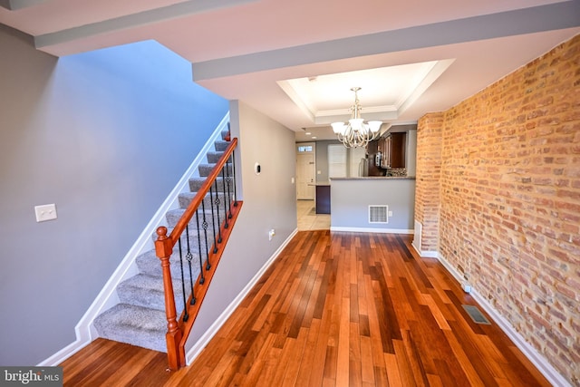 6 N Luzerne Ave, Baltimore, MD 21224 - corridor with a chandelier, a raised ceiling, hardwood / wood-style flooring, stairs, and baseboards