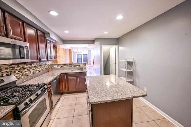 6 N Luzerne Ave, Baltimore, MD 21224 - kitchen featuring appliances with stainless steel finishes, a chandelier, backsplash, a sink, and a center island