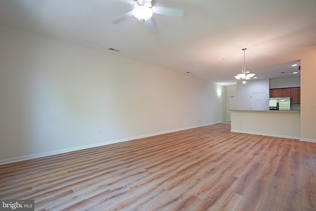unfurnished living room featuring light wood-type flooring, ceiling fan, baseboards, recessed lighting, and a chandelier
