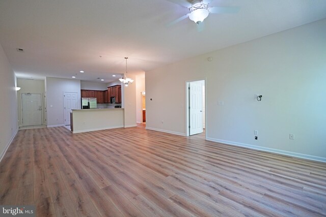 unfurnished living room with light wood-type flooring, ceiling fan, baseboards, a chandelier, and recessed lighting