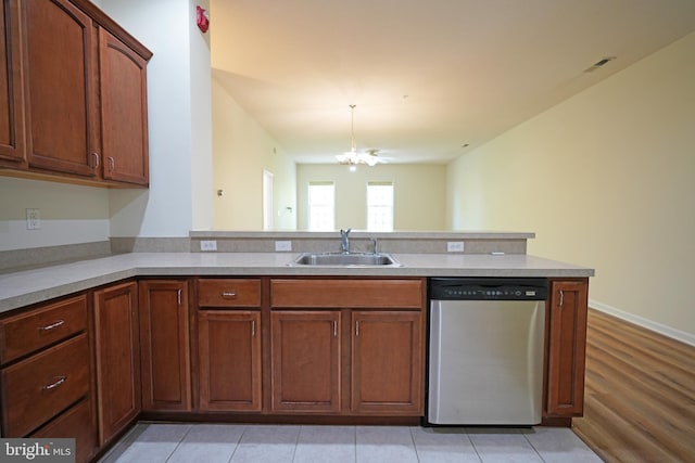 kitchen featuring dishwasher, a sink, a chandelier, a peninsula, and light countertops