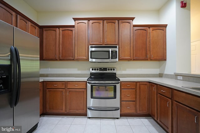 kitchen with appliances with stainless steel finishes, light countertops, and light tile patterned floors