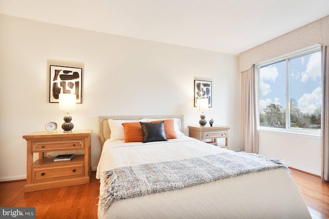 bedroom featuring baseboards and wood finished floors