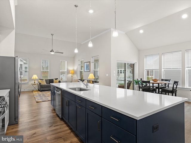 kitchen with open floor plan, light countertops, a sink, and appliances with stainless steel finishes