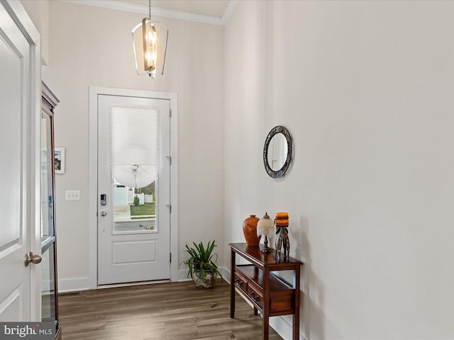 foyer entrance featuring baseboards, ornamental molding, and wood finished floors