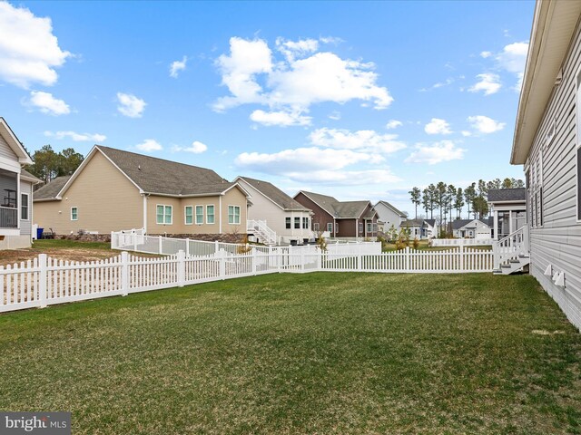 view of yard featuring entry steps, fence private yard, and a residential view