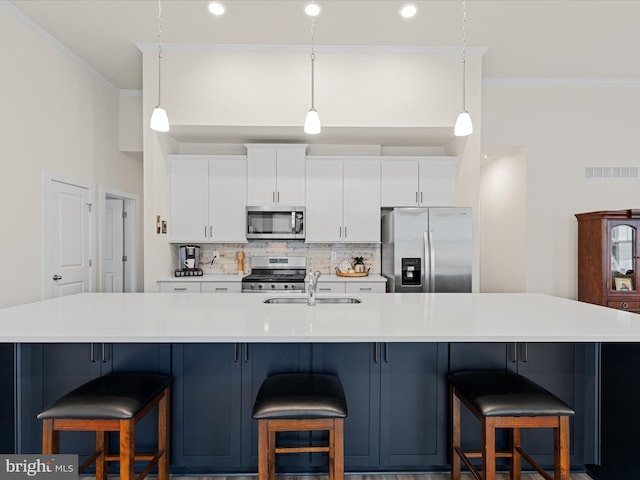 kitchen with visible vents, ornamental molding, appliances with stainless steel finishes, a sink, and backsplash