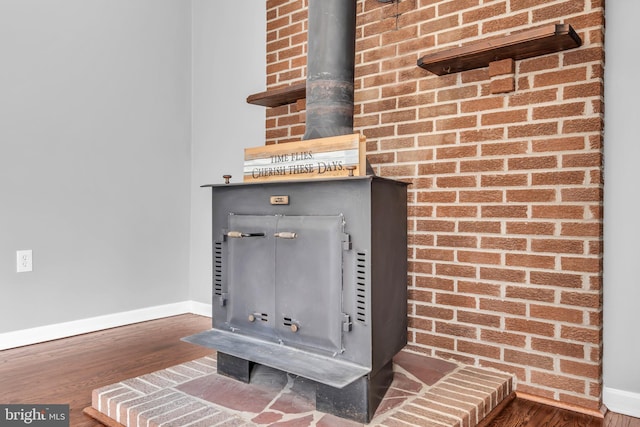 room details featuring baseboards, wood finished floors, and a wood stove